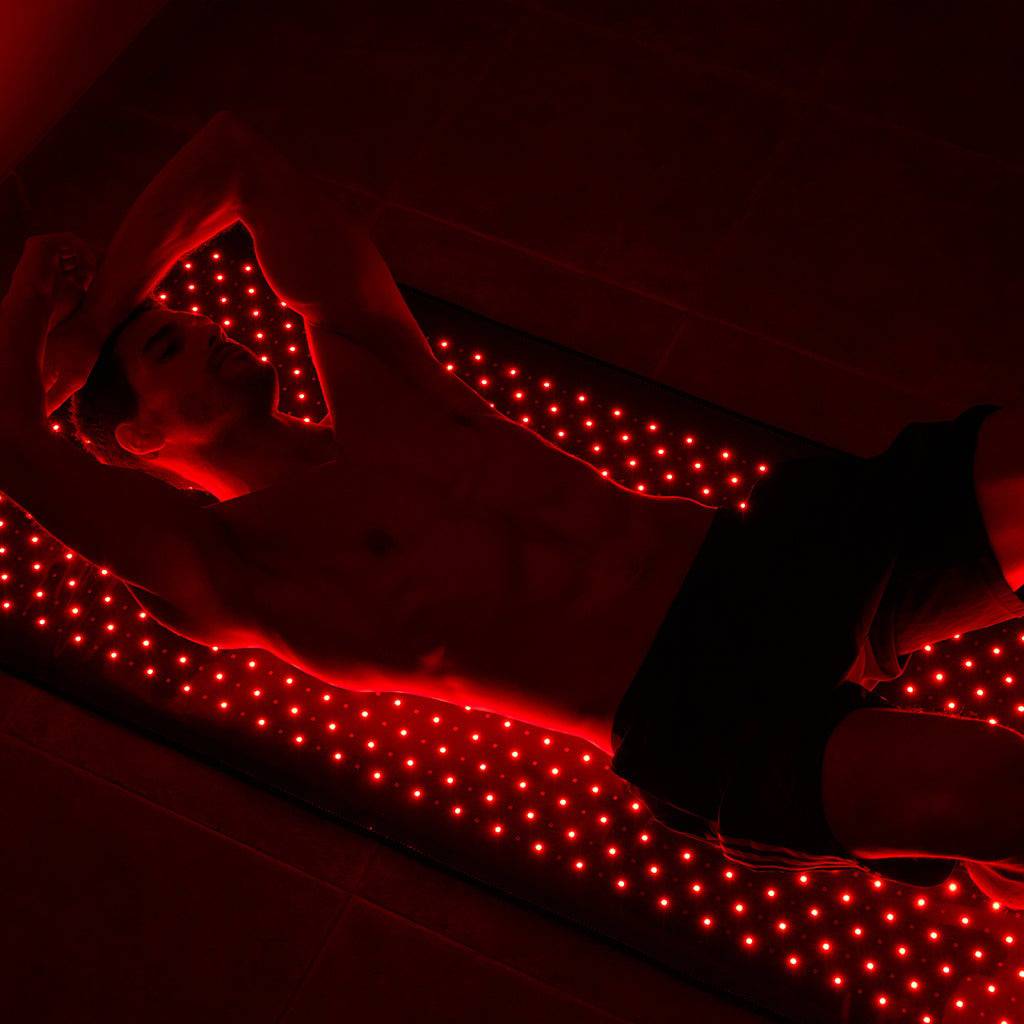 Man lying on BlinkRecover red light therapy bag for full-body treatment, targeting muscle recovery and skin rejuvenation.