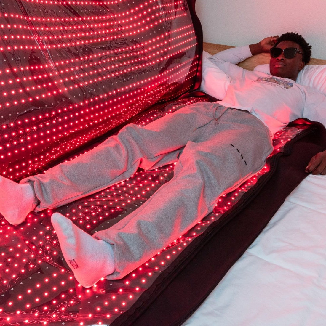 Person using a full-body red light therapy bag for pain relief and muscle recovery. The BlinkRecover bag provides advanced LED light therapy to promote healing, reduce inflammation, and improve skin health.