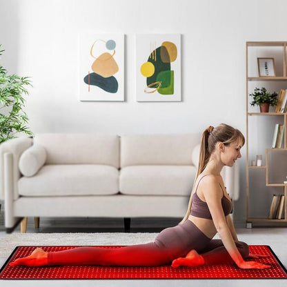 Woman performing yoga stretch on red light therapy mat for improved flexibility, recovery, and muscle relief in a modern living room.